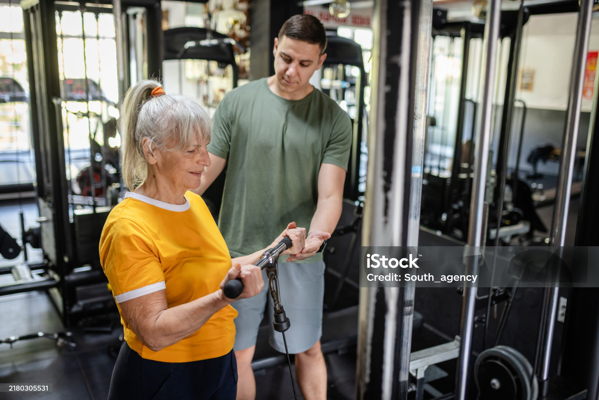 Personal trainer begeleidt een 50-plusser bij het trainen